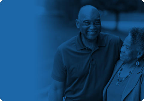 Blue banner with a photo superimposed over it showing a senior couple standing outside together on a sunny day. The man has his arm around the woman's arm, and they are both smiling.